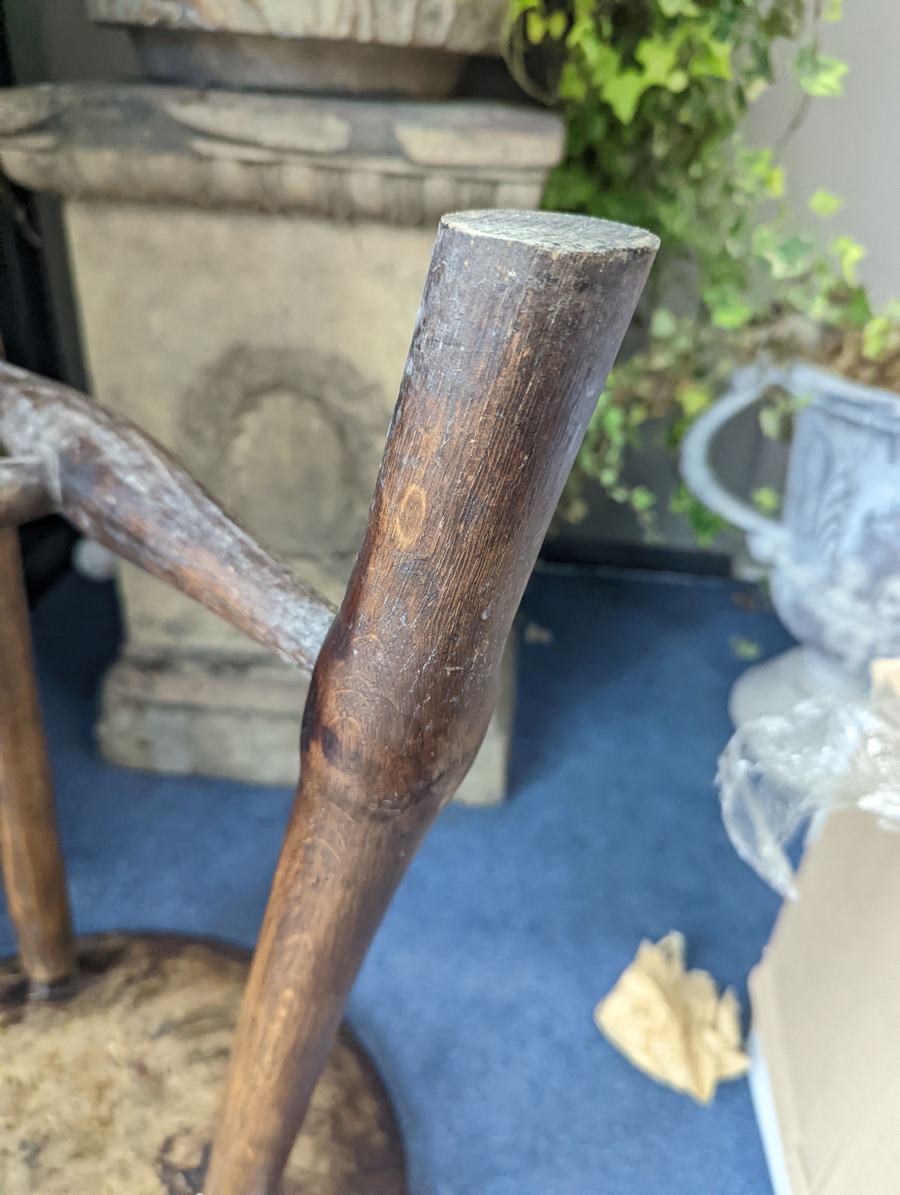 A circular burr elm and ash primitive cricket table with T shaped stretcher, diameter 44cm, height 61cm